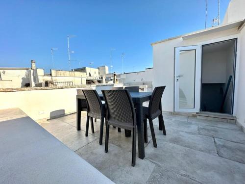 een zwarte eettafel en stoelen op een balkon bij Casa Bell'ora in Ostuni