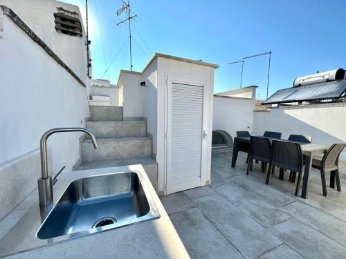 een keuken met een wastafel en een tafel op een patio bij Casa Bell'ora in Ostuni