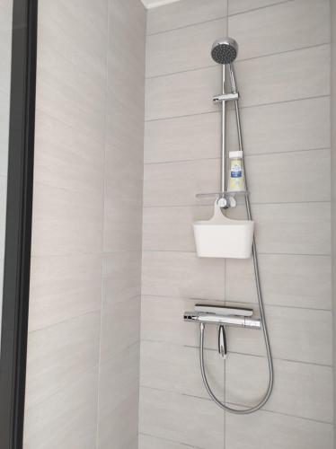 une douche dans une salle de bain avec une pomme de douche dans l'établissement Charmant duplex à 2 pas de la plage, à Le Portel