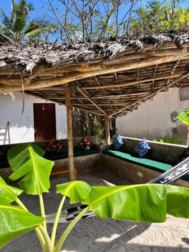 a building with a thatched roof with plants in front of it at Karanga Bungalows in Michamvi