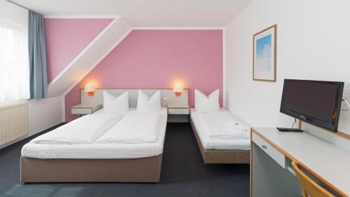 Habitación de hotel con 2 camas y TV de pantalla plana. en Motel Hormersdorf, en Hormersdorf