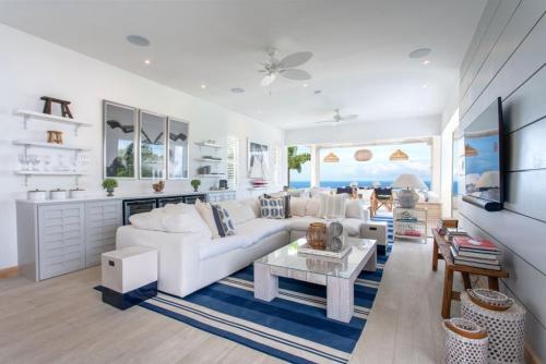 a living room with a white couch and a table at Incredible views of sea from the pool - Cool Breeze villa in Saint James