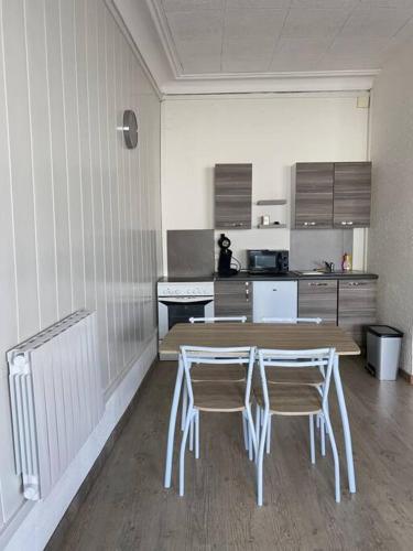 une cuisine avec une table en bois et deux chaises dans l'établissement Studio spacieux proche du centre ville, à Montceau-les-Mines