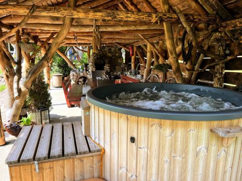 a hot tub in a wooden building with a bench at CHILL Village in Nowinka