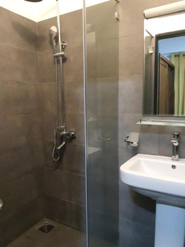 y baño con ducha y lavamanos. en Green Lake View Condo Two Bed Room Apartment, en Nuwara Eliya