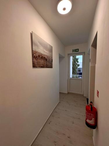 a hallway with a painting on the wall and a red suitcase at Elbląska Noclegi in Łódź