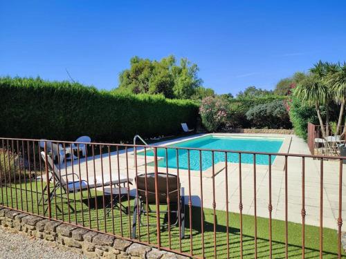une clôture avec deux chaises à côté d'une piscine dans l'établissement Lo Mas dei Santés, à Bédarrides