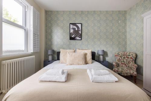 a bedroom with a large bed with two towels on it at The East Dulwich House in London