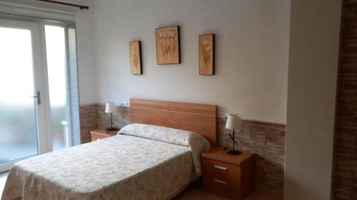 a bedroom with a bed and two pictures on the wall at Beiramar2 in Muxia