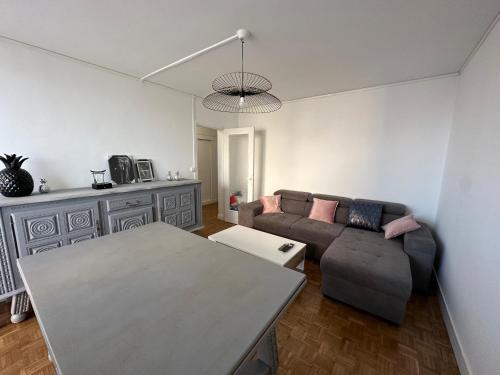 - un salon avec un canapé et une table dans l'établissement Chambre dans Résidence avec parking - proche Zenith, à Saint-Étienne-du-Rouvray