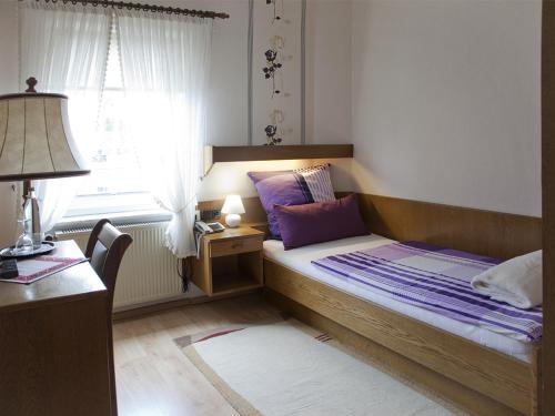 a bedroom with a bed and a desk and a window at Berleburger Hof in Bad Berleburg