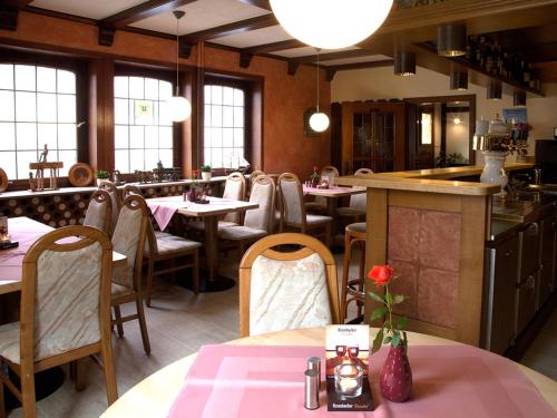 a restaurant with tables and chairs and a bar at Berleburger Hof in Bad Berleburg