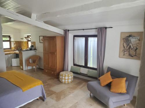 a bedroom with a bed and a couch and a window at Le Jas des Cannebieres in Villeneuve