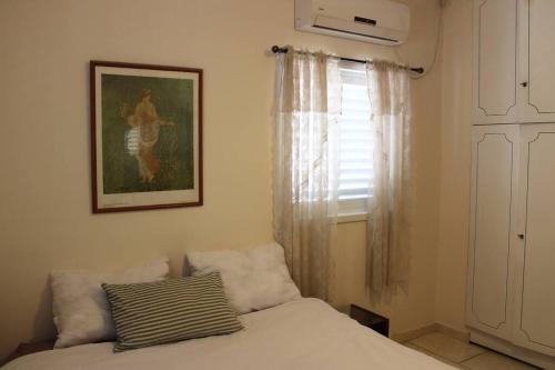 - une chambre avec un lit et une photo sur le mur dans l'établissement VINTAGE FLAT STEPS FROM THE BEACH, à Tel Aviv