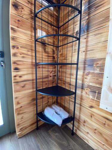 a black shelf in a room with a wooden wall at T&S suite in Dāliyat el Karmil