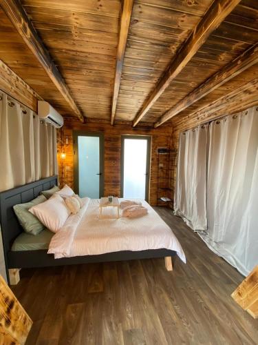 a bedroom with a large bed in a room with wooden ceilings at T&S suite in Dāliyat el Karmil