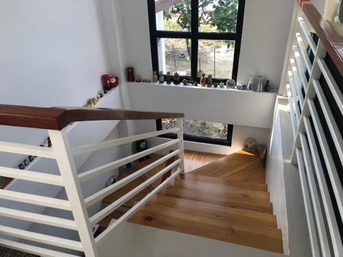 a staircase in a home with a white stair case at Sea Breeze Beach House near sandbars and beaches and near to Danao port in Alimañgo