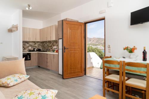 a kitchen and a living room with a table at Akrotiri Apartments in Makry Gialos