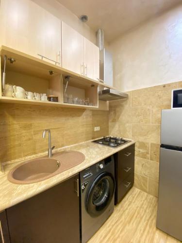 a kitchen with a sink and a washing machine at GM Rest House in Tsaghkadzor