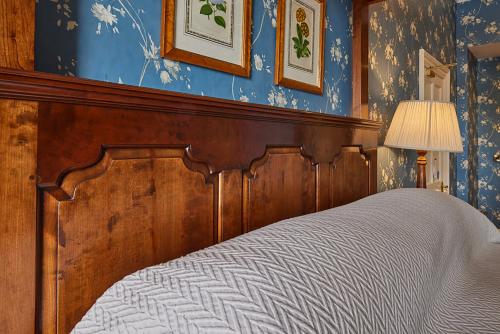a bed with a wooden head board in a bedroom at Perryville House in Kinsale