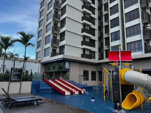 a swimming pool with a slide in a hotel at TWC Luxury Seaview Suites Bali Residences Malacca in Melaka