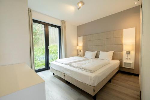 a bedroom with a large bed and a large window at Villas Winterberg in Winterberg