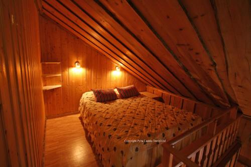 una camera da letto con letto in una camera in legno di Holiday Home Kantapää A3 a Luosto