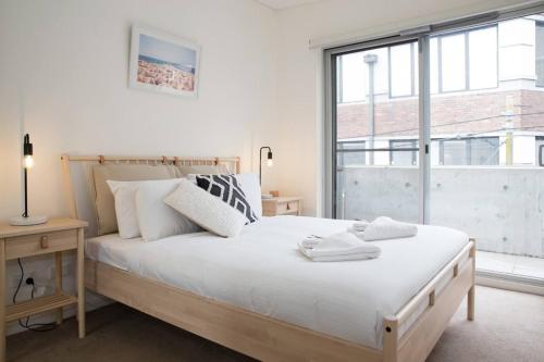 a bedroom with a bed and a large window at 'Perfectly Pyrmont' Sun-drenched Nordic Simplicity in Sydney
