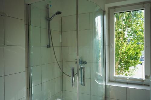 La salle de bains est pourvue d'une douche avec une porte en verre. dans l'établissement unique: 5 bedroom - 2 Bathroom - kitchen - central, à Bremerhaven