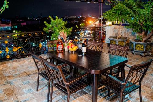 a wooden table and chairs on a balcony at night at Victory Hotel in Hanoi