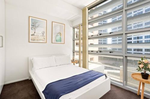 a bedroom with a bed and a large window at 'Sussex Suite' Sunny City Living by Darling Harbour in Sydney