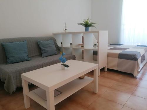 ein Wohnzimmer mit einer Couch und einem Tisch in der Unterkunft Helios Studio Drago in Costa Del Silencio