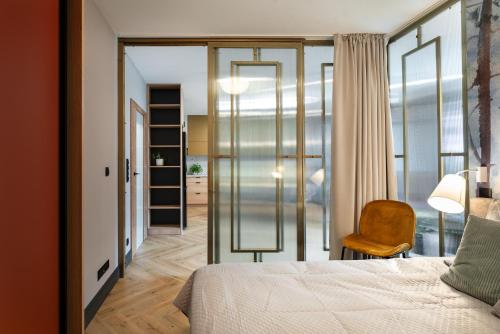 1 dormitorio con 1 cama y 1 silla en una habitación en Apartament SezamkowaSKC, en Skierniewice