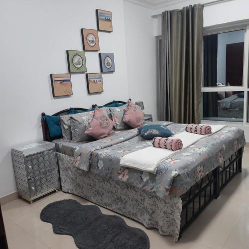 1 dormitorio con cama y ventana con almohadas en Beach side Private Room for Travelers, en Sharjah