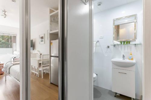 雪梨的住宿－Cosy Inner-city Hideaway in the Heart of Annandale，白色的浴室设有水槽和卫生间。
