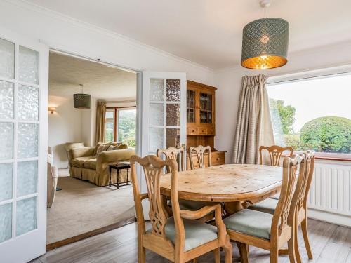 - une salle à manger avec une table et des chaises en bois dans l'établissement Pass the Keys Charming Harbourside Cottage, à Emsworth