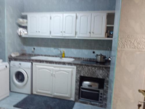 uma cozinha com um lavatório e um micro-ondas em Appartement centre ville em Larache