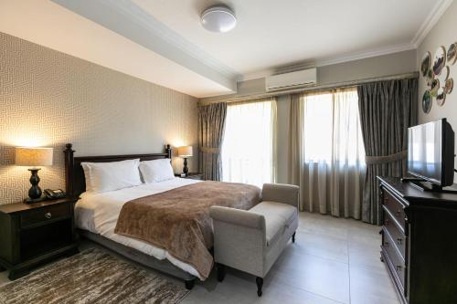une chambre d'hôtel avec un lit et une télévision dans l'établissement The African Penguin Guesthouse, à Pretoria