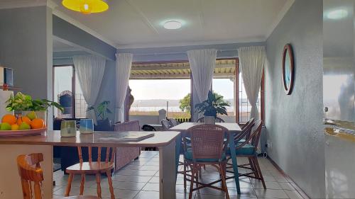 a kitchen and dining room with a table and chairs at Paradise Beach Cottage in Jeffreys Bay