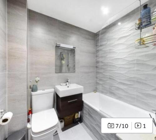 a bathroom with a sink and a toilet and a tub at Charming 2-Bed Apartment in Christchurch in Christchurch