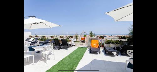 un patio con tavoli e sedie sul tetto di Riviera Mare Beach Life Hotel a Rimini