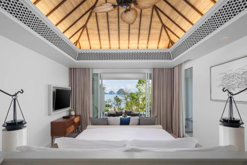 a bedroom with a large bed and a living room at Banyan Tree Krabi - SHA Extra Plus in Tab Kaek Beach