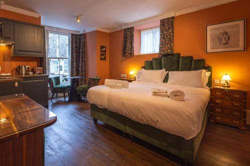 a bedroom with a large bed and a kitchen at The Fanny Talbot in Barmouth