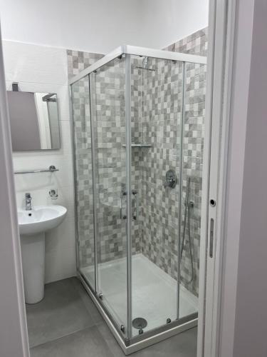 La salle de bains est pourvue d'une douche en verre et d'un lavabo. dans l'établissement Villa Donnarumma, à Castellammare di Stabia