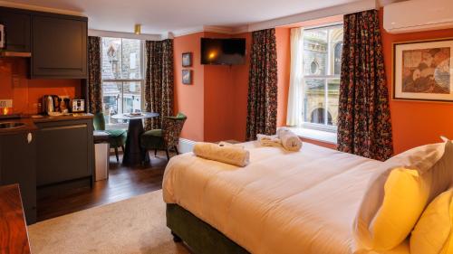 a bedroom with a large bed and a kitchen at The Fanny Talbot in Barmouth