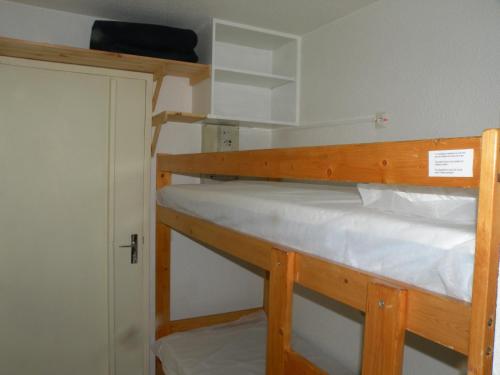 a bunk bed in a small room with a door at Au Coeur De La Station in Les Deux Alpes