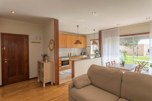 a living room with a couch and a kitchen at Litoral beach Apartment -- Esposende in Esposende