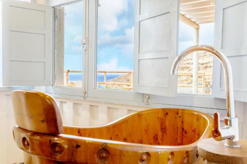 a wooden tub in a bathroom with windows at Eco Vineyard Cottage - Fantastic Views - 5 mins drive to Arrieta beach in Tabayesco