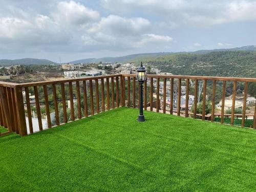 a balcony with a lamp on the grass at T&S suite in Dāliyat el Karmil
