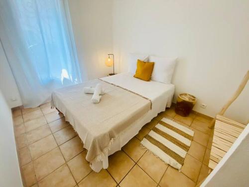 een slaapkamer met een groot wit bed met gele kussens bij ''Americo'' Joli 3 pièces climatisé Quartier Haut in Sète